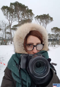 ragazza con macchina fotografica tra la neve