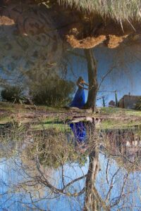 Immagine di ragazza e un albero riflessi nell'acqua