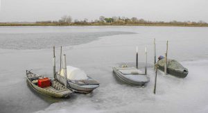 Barche tra il ghiaccio in laguna di Venezia